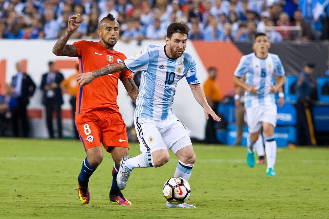 Argentina's Lionel Messi (10) takes on Chile's Arturo Vidal (8).